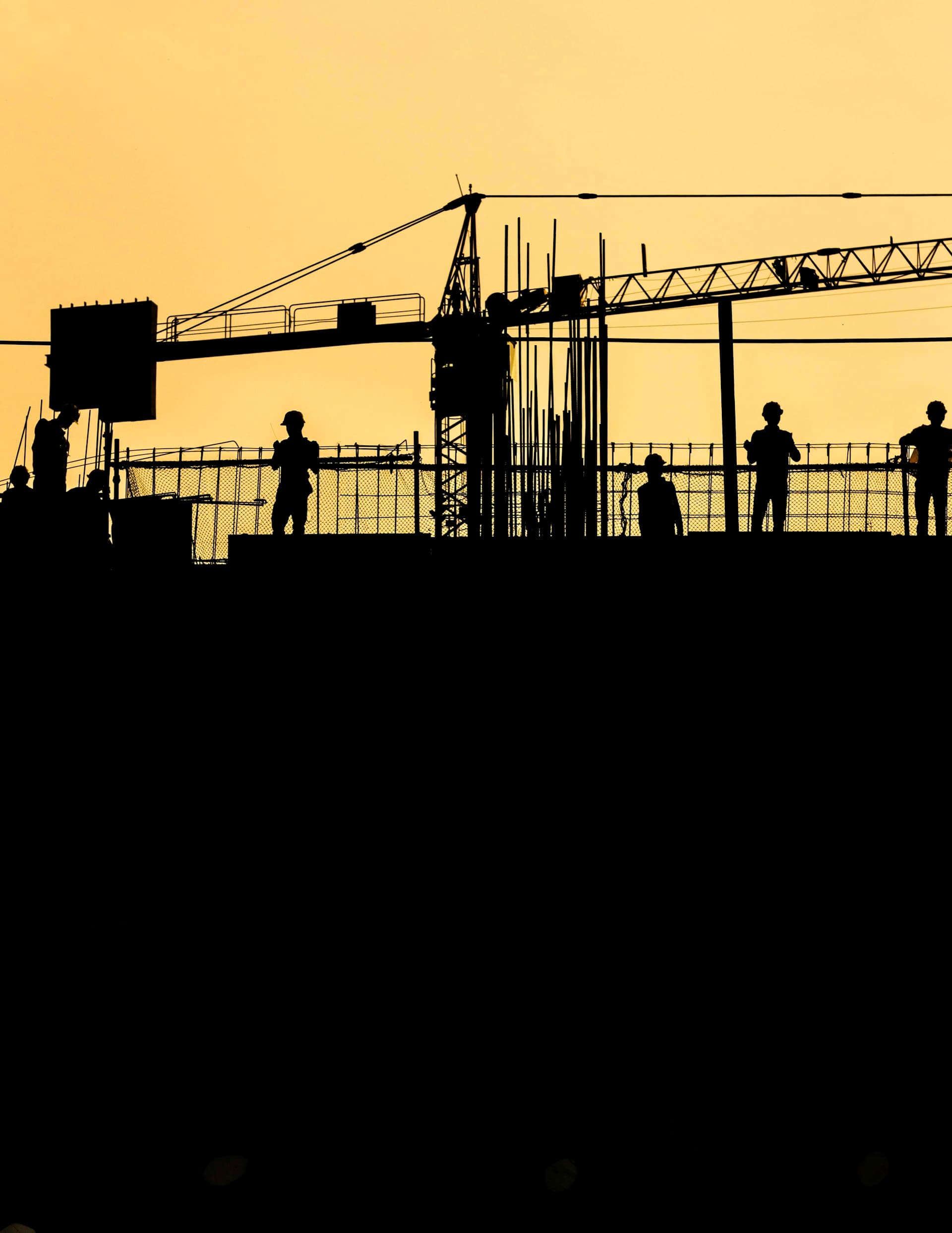 Construction crew working at a job site at sunset