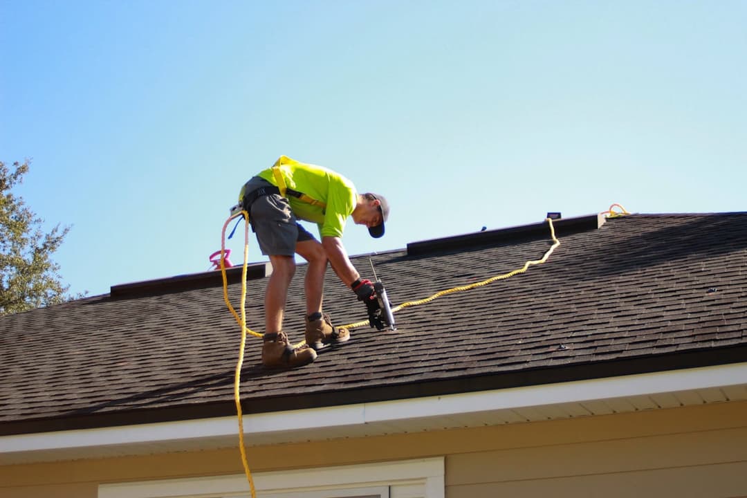 Roofer installing shingles on a residential roof